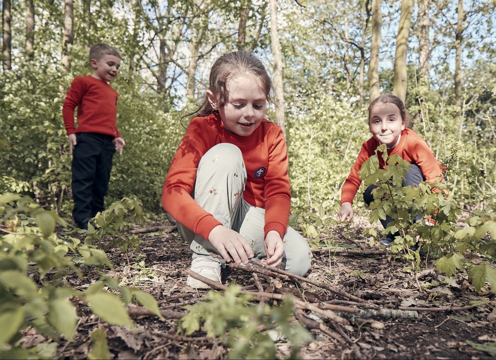 Three squirrel Scouts play in the woods